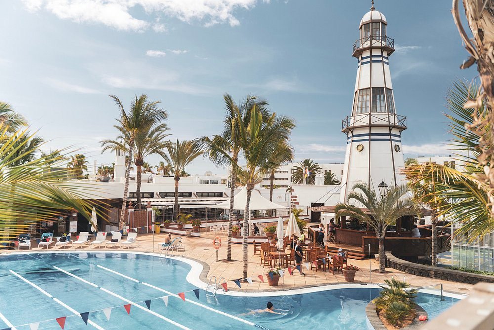 Outdoor pool with iconic lighthouse tower at luxury Hotel Fariones, Puerto del Carmen Lanzarote