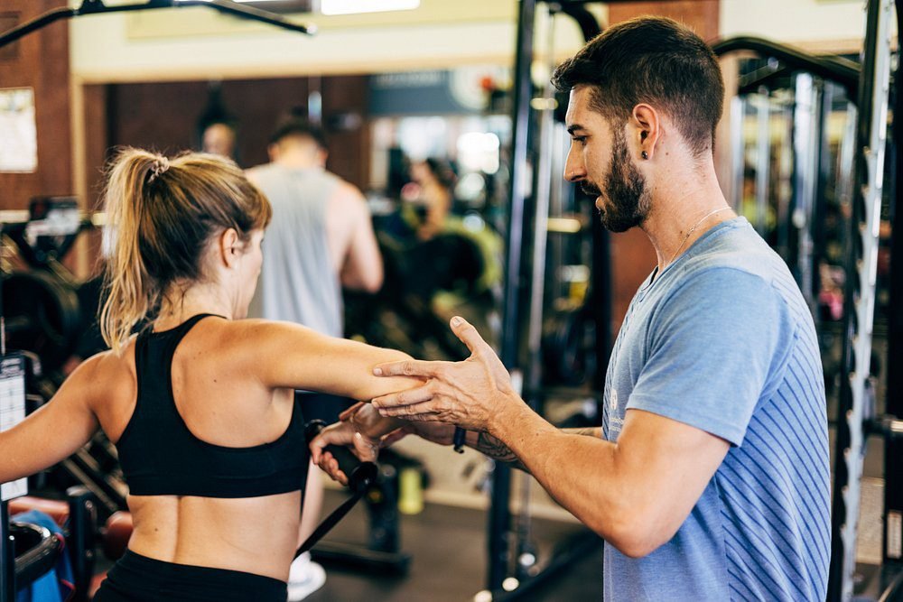 Personal trainer assisting guest at the fitness center of luxury Hotel Fariones Lanzarote