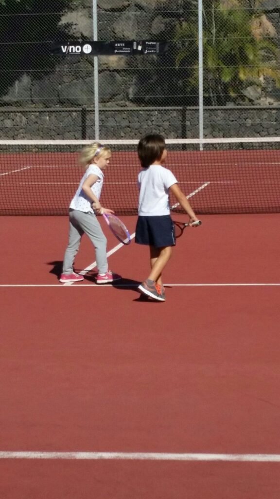Two children playing tennis on the court at luxury Hotel Fariones Lanzarote, Puerto del Carmen